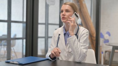 Young Doctor Talking on Phone in Clinic