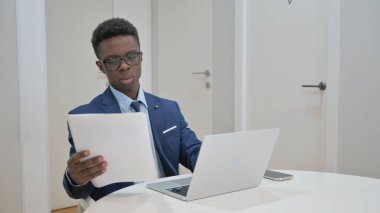 Afrikalı İşadamı Belgeleri İnceledi ve Dizüstü bilgisayarda Çalıştı