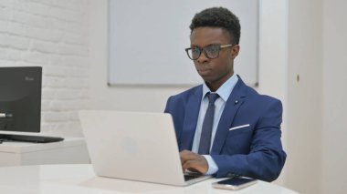 Laptop üzerinde çalışan odaklı Afrikalı İşadamı