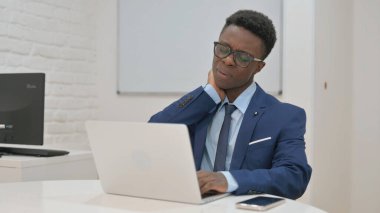 Dizüstü bilgisayarda çalışırken boynu ağrıyan genç iş adamı