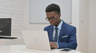 Dizüstü bilgisayarda özenle çalışan genç profesyonel