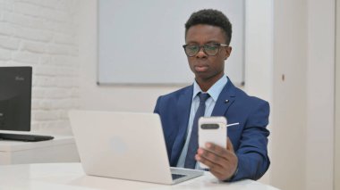 İş Adamı Çalışma Masasında Telefonu Kontrol Ediyor