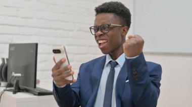 Heyecanlı iş adamı telefonda kutlama yapıyor.