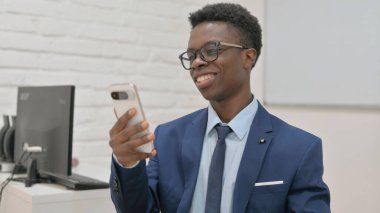 Gülümseyen Afrikalı İş Adamı Video Görüşmesi İçin Akıllı Telefon Kullanıyor