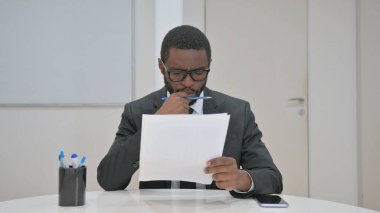 Ofis masasında Düşünceli İşadamı Belgeleri İnceleme