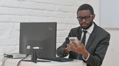 İşadamı Masaüstü Bilgisayarı ile Akıllı Telefon Kullanıyor