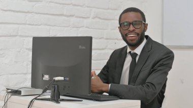 Bilgisayarda çalışırken gülümseyen neşeli iş adamı