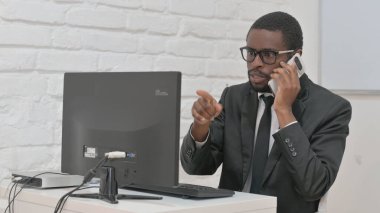 İş Adamı Telefonda Konuşuyor ve Bilgisayarda Çalışıyor