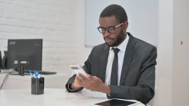 İş Adamı Masasında Akıllı Telefon Kullanıyor