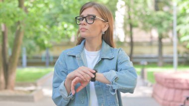 Genç Kadın Smartwatch Açık havada Zamanı Kontrol Ediyor