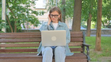 Baş Ağrısı Olan Kadın Park 'ta Dizüstü bilgisayar Kullanıyor