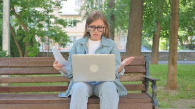 Açık havada çalışırken hayal kırıklığını ifade eden sıradan kadın.