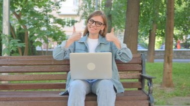 Açık havada otururken Dizüstü bilgisayarından vazgeçen kadın