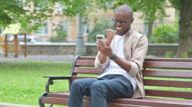 Genç Afrikalı Adam Park Benç 'inde Telefon Kullanırken Heyecan Veriyor