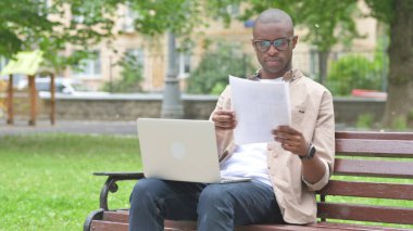 Genç Afrikalı Adam Park 'ta Laptop ile Belgeleri İnceleyecek