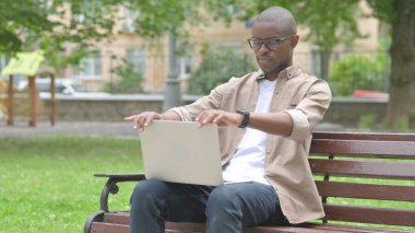 Genç Afrikalı Adam Bench 'ten dizüstü bilgisayarla ayrılıyor.