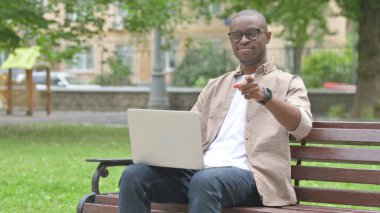 Genç Afrikalı Adam Laptop 'la doğrudan izleyiciye bakıyor.