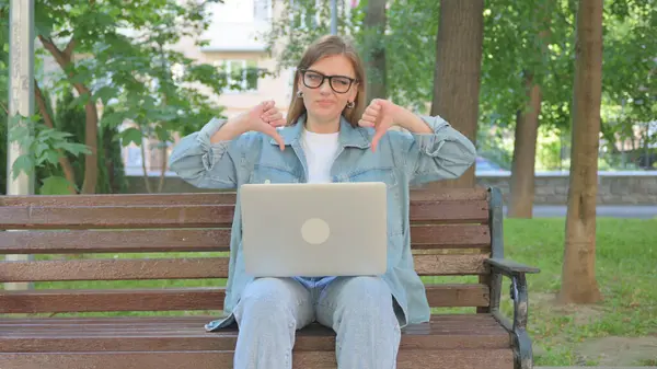 Kadın Dışarıda Otururken Dizüstü bilgisayarla Başparmak Veriyor