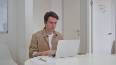 Dizüstü bilgisayarında Başağrısı Yazan Genç Yaratıcı Adam