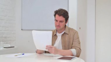 İş yerinde Belgeleri Kutlayan Genç Adam