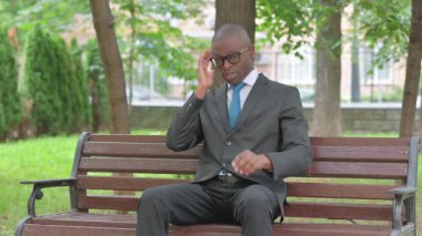 Afrikalı İşadamı parkta baş ağrısı çekiyor.