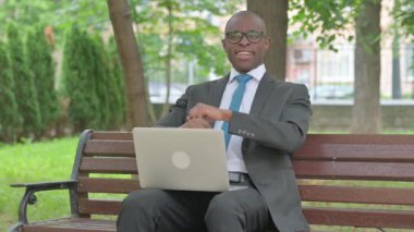 Afrikalı İşadamı Park 'ta dizüstü bilgisayarla gülümsüyor