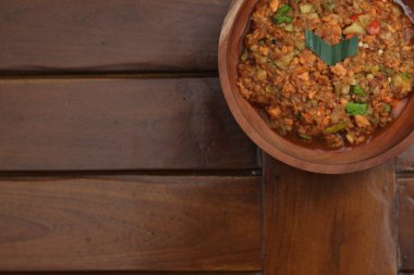 a close up Rujak Bebek or smashed fruit which is made from raw fruit crushed in a mortar and pestle and added with shrimp paste, chili and brown sugar. Indonesian traditional food photo concept.
