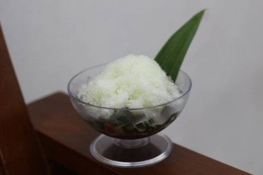 Es Kacang Merah or a cold drink made from red beans boiled with brown sugar served with coconut milk, shaved ice and covered with sweetened condensed milk chocolate and syrup. Indonesian traditional food photo concept.