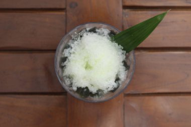Es Kacang Merah or a cold drink made from red beans boiled with brown sugar served with coconut milk, shaved ice and covered with sweetened condensed milk chocolate and syrup. Indonesian traditional food photo concept.