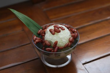 Es Kacang Merah ya da hindistan cevizi sütü, buzlu traş edilmiş buzla servis edilen ve yoğunlaştırılmış sütlü çikolata ve şurupla kaplanmış kahverengi şekerle kaynatılmış kırmızı fasulyeden yapılan soğuk bir içecek. Endonezya geleneksel yemek fotoğrafı konsepti.