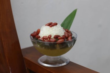 Es Kacang Merah or a cold drink made from red beans boiled with brown sugar served with coconut milk, shaved ice and covered with sweetened condensed milk chocolate and syrup. Indonesian traditional food photo concept.