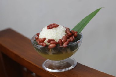 Es Kacang Merah ya da hindistan cevizi sütü, buzlu traş edilmiş buzla servis edilen ve yoğunlaştırılmış sütlü çikolata ve şurupla kaplanmış kahverengi şekerle kaynatılmış kırmızı fasulyeden yapılan soğuk bir içecek. Endonezya geleneksel yemek fotoğrafı konsepti.