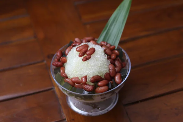 stock image Es Kacang Merah or a cold drink made from red beans boiled with brown sugar served with coconut milk, shaved ice and covered with sweetened condensed milk chocolate and syrup. Indonesian traditional food photo concept.