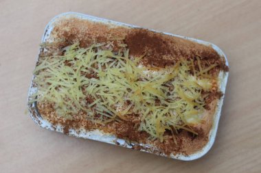 a close up of klapertart which is a typical food from Manado, Indonesia. Made from young coconut meat, sugar, flour, almonds, milk, butter, eggs, cinnamon and grated cheese. Indonesian traditional food photo concept.