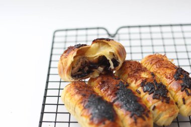 a close up of Chocolate Cheese Bolen. made of flour, cheese, chocolate, with banana filling. served on a cake rack. isolated white background.