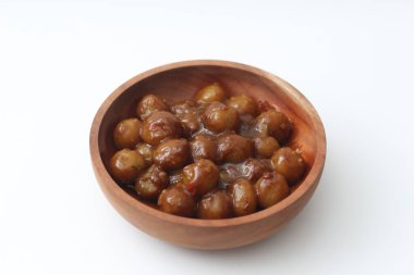 a close up of cilok. Made from tapioca flour and a delicious peanut sauce. served in wooden bowl isolated on white background.