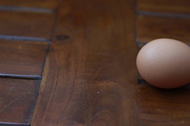 a close up of a chicken egg isolated on a natural patterned wooden background. healthy food ingredients photo concept.