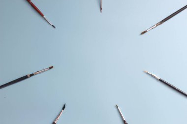 a close up of a painting brush isolated on a blue background. concept photo art.