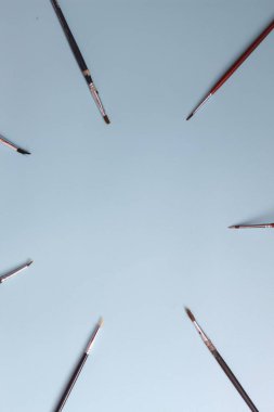 a close up of a painting brush isolated on a blue background. concept photo art.