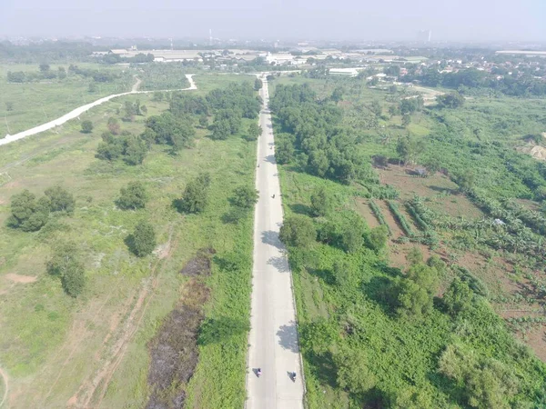 stock image aerial view of Klapanunggal highway between trees and green open space.