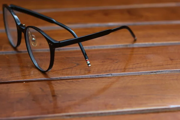 Close Eyeglasses Black Frames Isolated Natural Patterned Wooden Background — Zdjęcie stockowe