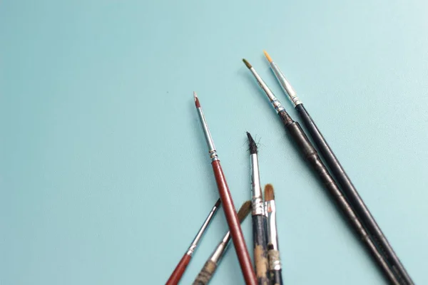 stock image a close up of a painting brush isolated on a blue background. concept photo art.