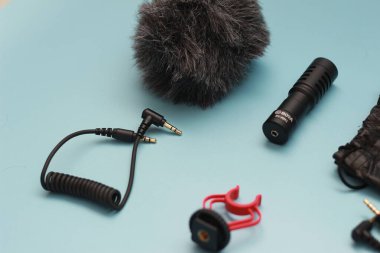 a close up of microphone for mobile phone and camera isolated on blue background. sound technology photo concept.