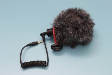 a close up of microphone for mobile phone and camera isolated on blue background. sound technology photo concept.