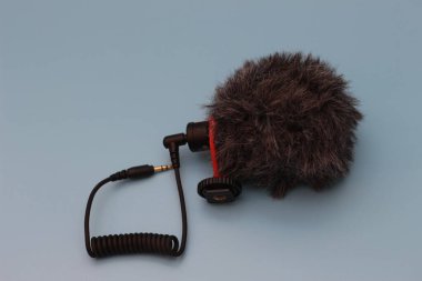a close up of microphone for mobile phone and camera isolated on blue background. sound technology photo concept.