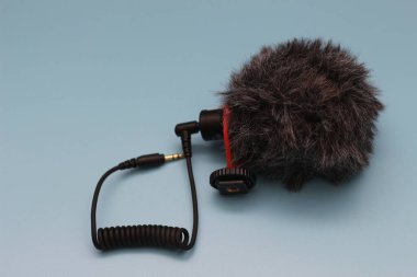 a close up of microphone for mobile phone and camera isolated on blue background. sound technology photo concept.