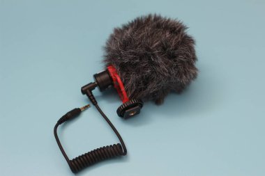 a close up of microphone for mobile phone and camera isolated on blue background. sound technology photo concept.