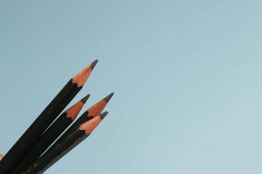 a close up of a bunch of pencils isolated on a blue background. creative photo concept.