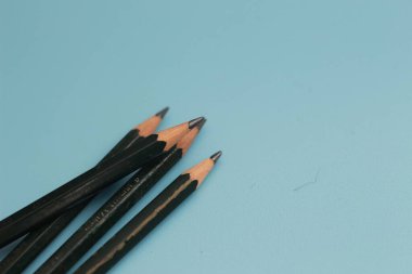 a close up of a bunch of pencils isolated on a blue background. creative photo concept.