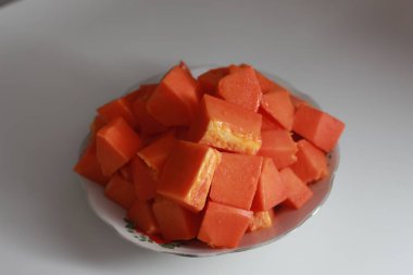 Papaya slices served on a white plate isolated on a white background. concept of healthy food for body digestion.